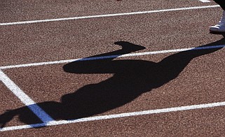 A runner casts a shadow during warmups during a track and field meet in Lawrence, Kan., in this April 14, 2010 file photo. (AP/Orlin Wagner)
